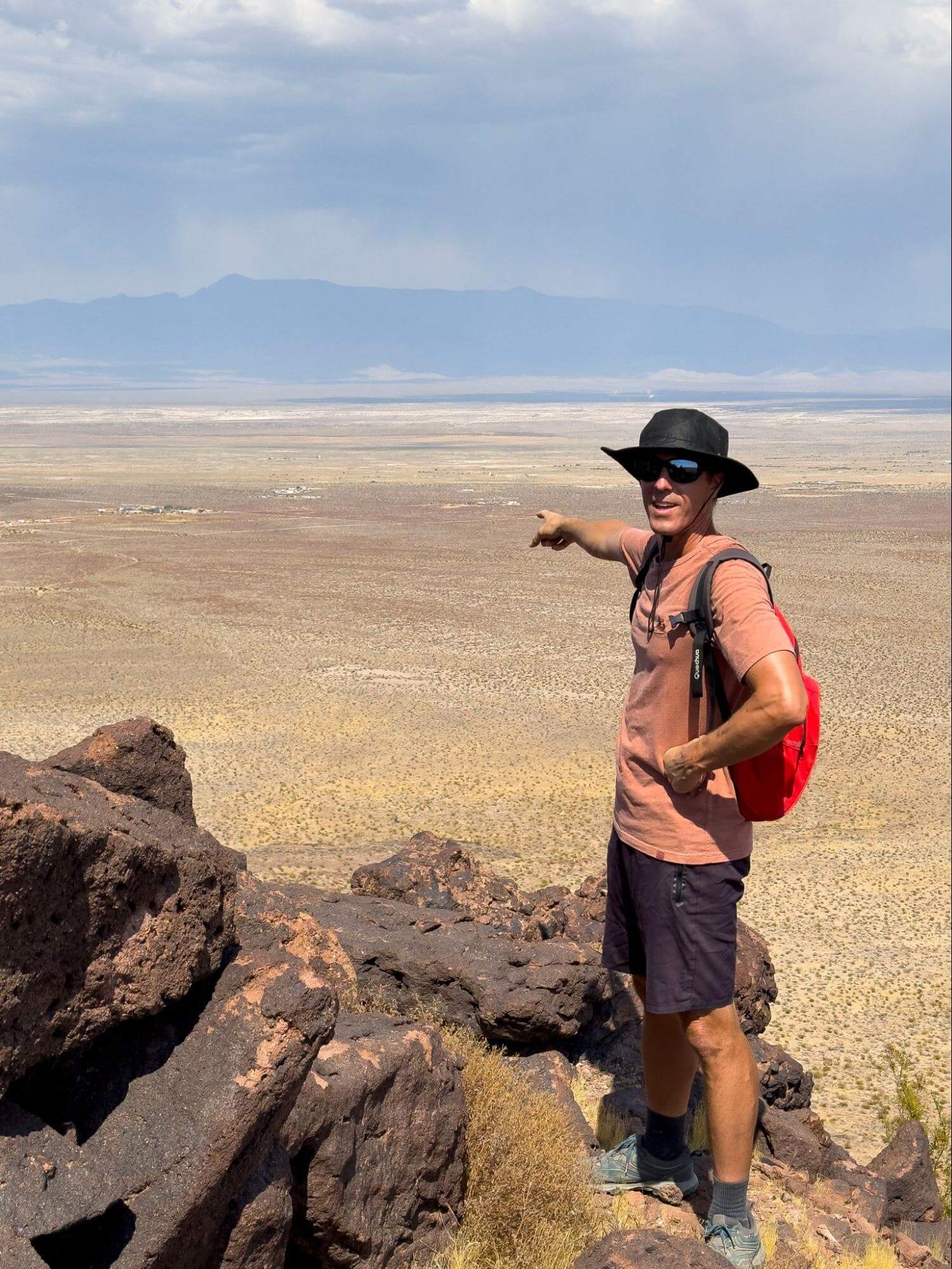 Baisle pointing to Sunbaked Farm from Tequila Peak